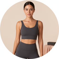 Headshot of fitness influencer Taylor Reed, a woman with a natural smile, wearing a charcoal activewear top against a soft cr